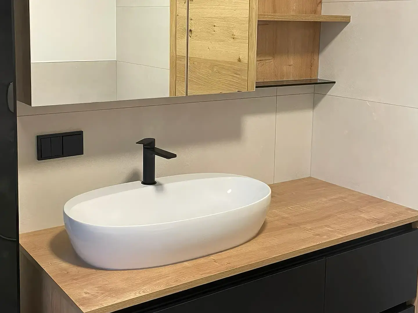 Modernes Badezimmer mit Waschbecken und schwarzen Armaturen